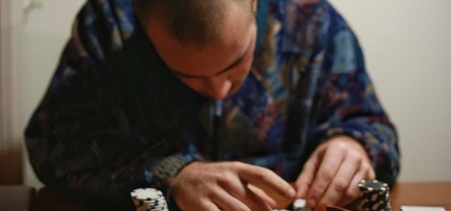 man in blue and black long sleeve shirt playing poker