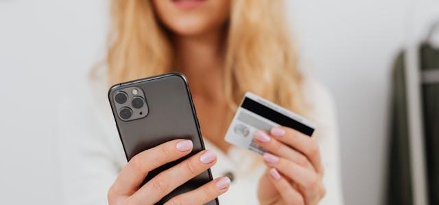 Woman holding bank card and mobile phone