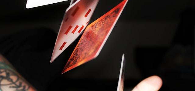 a person holding up playing cards in their hand a person holding up playing cards in their hand